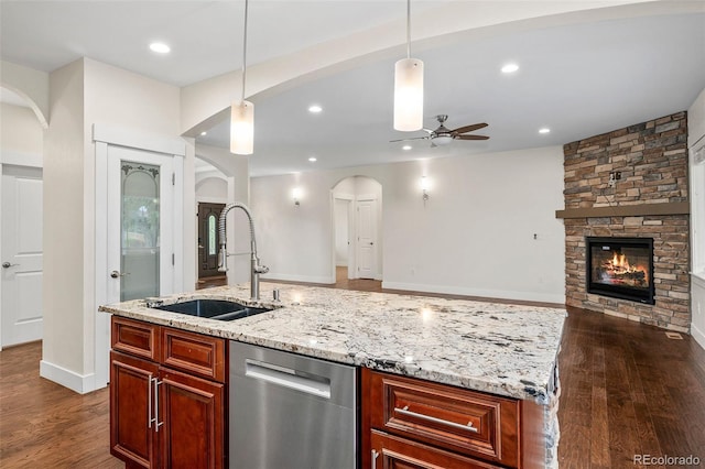 5372 W 68th Ave, Arvada, CO 80003 - kitchen featuring a ceiling fan, dishwasher, a stone fireplace, a sink, and arched walkways