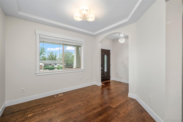 5372 W 68th Ave, Arvada, CO 80003 - spare room featuring visible vents, dark wood finished floors, a chandelier, arched walkways, and a tray ceiling