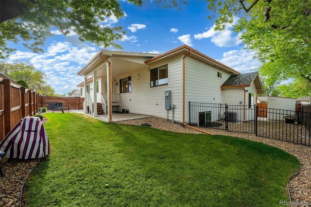 5372 W 68th Ave, Arvada, CO 80003 - back of property featuring cooling unit, a patio, a lawn, and a fenced backyard