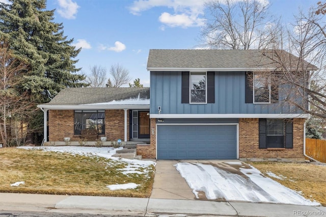 tri-level home with driveway, brick siding, an attached garage, and a shingled roof