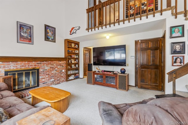 living room featuring built in features, carpet, stairway, a high ceiling, and a brick fireplace