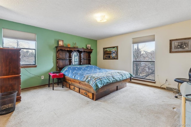 carpeted bedroom featuring multiple windows, baseboards, and a textured ceiling