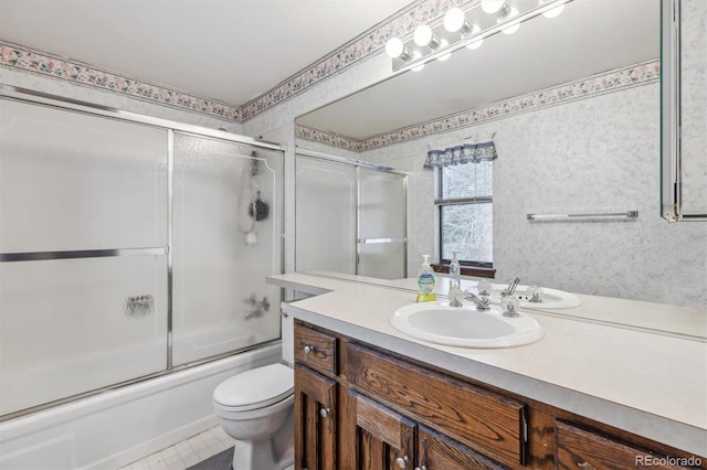 full bath featuring combined bath / shower with glass door, vanity, and toilet