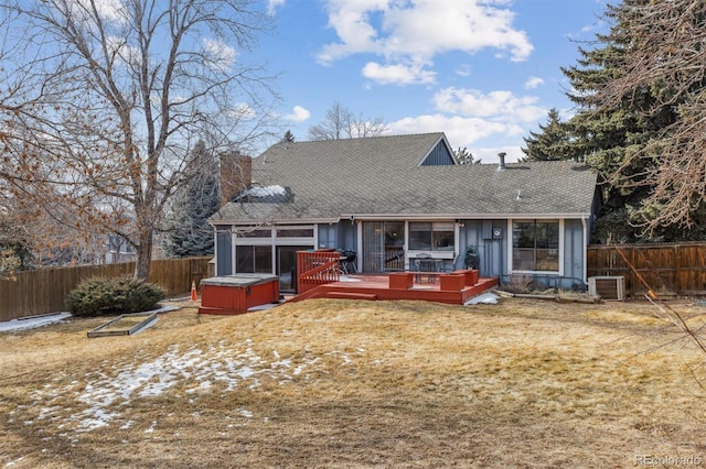 view of front facade with a chimney, a hot tub, central AC unit, a fenced backyard, and a wooden deck