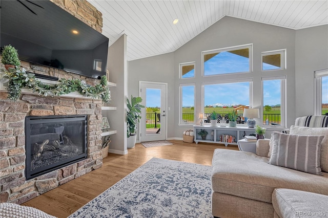 16256 Ridge Run Dr, Colorado Springs, CO 80908 - living area featuring a stone fireplace, wood finished floors, wooden ceiling, baseboards, and high vaulted ceiling