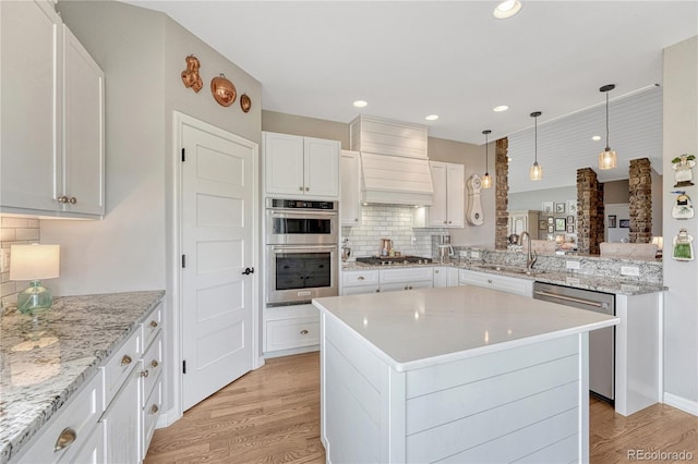 16256 Ridge Run Dr, Colorado Springs, CO 80908 - kitchen featuring custom range hood, stainless steel appliances, light wood-type flooring, backsplash, and a sink