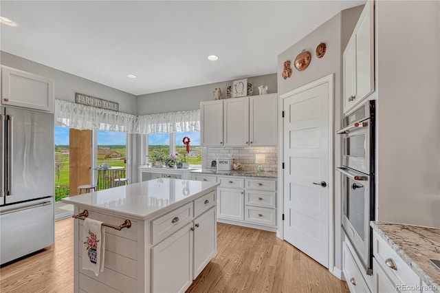 16256 Ridge Run Dr, Colorado Springs, CO 80908 - kitchen featuring appliances with stainless steel finishes, light wood finished floors, white cabinets, backsplash, and recessed lighting