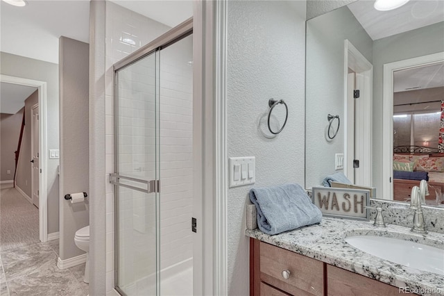 16256 Ridge Run Dr, Colorado Springs, CO 80908 - ensuite bathroom featuring a stall shower, vanity, toilet, a textured wall, and baseboards