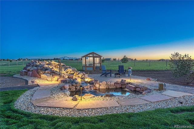 16256 Ridge Run Dr, Colorado Springs, CO 80908 - patio terrace at dusk with an outdoor fire pit, a greenhouse, and an outdoor structure