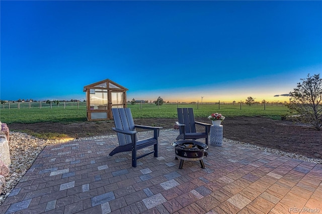 16256 Ridge Run Dr, Colorado Springs, CO 80908 - view of patio / terrace with a greenhouse, a fire pit, fence, an outdoor structure, and a view of countryside