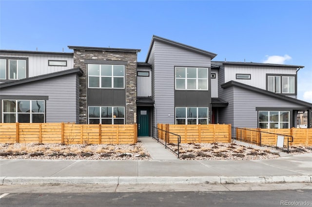 view of front of house featuring a fenced front yard and stone siding