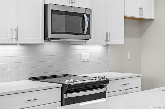 kitchen featuring stainless steel appliances, white cabinetry, tasteful backsplash, and light countertops