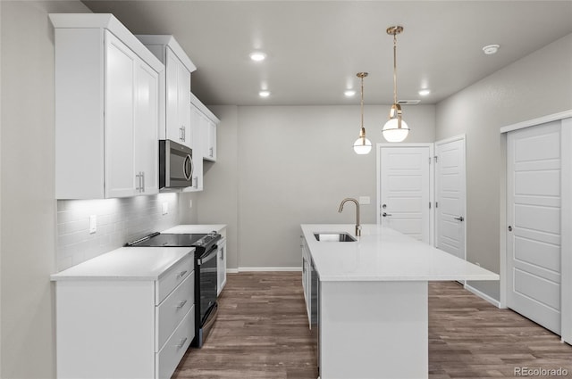 kitchen featuring stainless steel microwave, dark wood-type flooring, decorative backsplash, electric range, and a sink