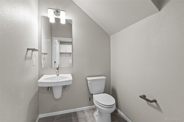 bathroom featuring baseboards, toilet, and vaulted ceiling