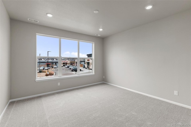 spare room with visible vents, recessed lighting, baseboards, and carpet floors