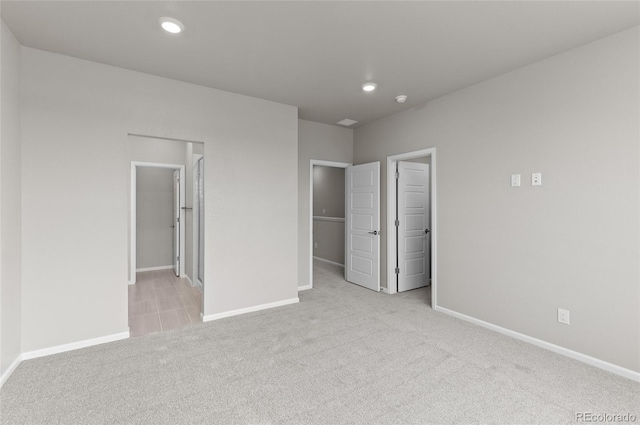 unfurnished bedroom with recessed lighting, a closet, carpet floors, baseboards, and a spacious closet