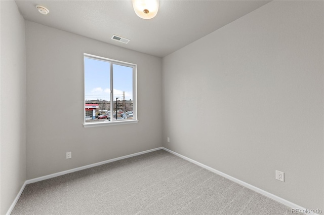 unfurnished room with visible vents, baseboards, and carpet