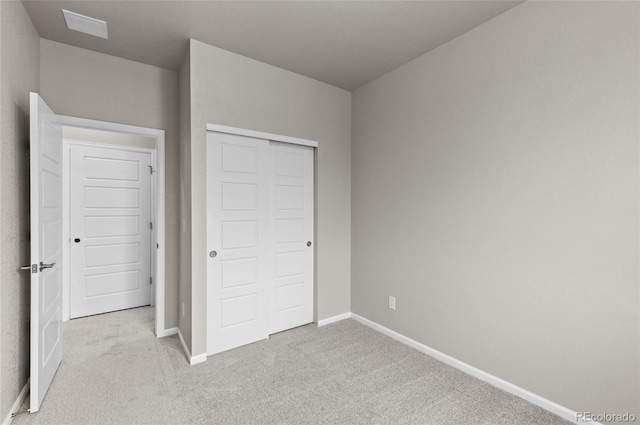 unfurnished bedroom with carpet flooring, baseboards, and a closet