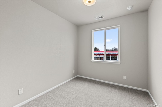 carpeted empty room with visible vents and baseboards