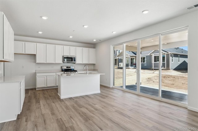 9082 Telluride Ct, Commerce City, CO 80022 - kitchen with a wealth of natural light, stainless steel appliances, light wood-type flooring, and visible vents