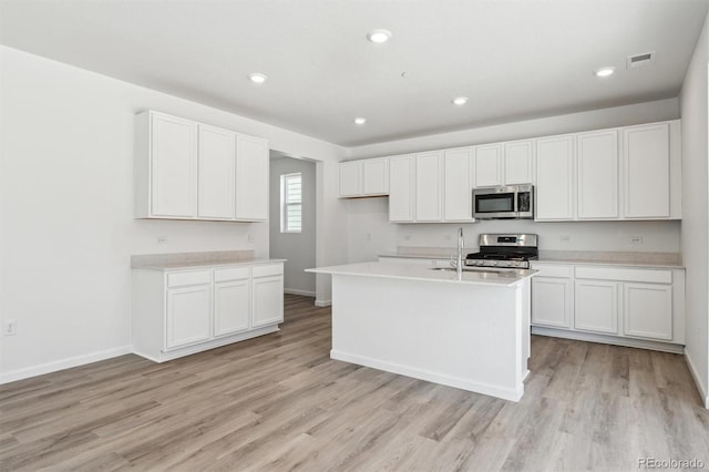 9082 Telluride Ct, Commerce City, CO 80022 - kitchen with light wood-type flooring, stainless steel appliances, visible vents, and white cabinetry