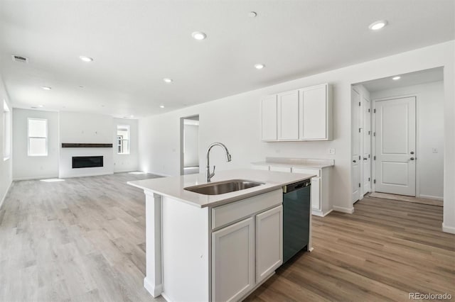 9082 Telluride Ct, Commerce City, CO 80022 - kitchen with a sink, light wood-type flooring, dishwashing machine, visible vents, and baseboards