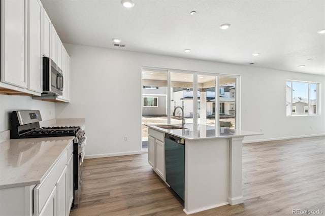 9082 Telluride Ct, Commerce City, CO 80022 - kitchen with a sink, stainless steel appliances, a center island with sink, light wood-type flooring, and recessed lighting