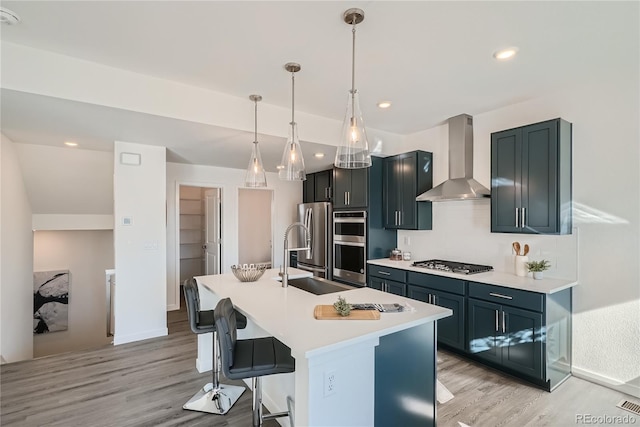 15336 W 68th Loop, Arvada, CO 80007 - kitchen with wall chimney exhaust hood, appliances with stainless steel finishes, light wood finished floors, a breakfast bar, and light countertops