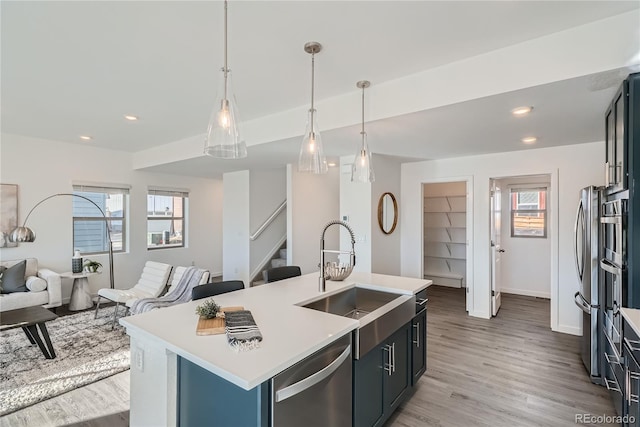 15336 W 68th Loop, Arvada, CO 80007 - kitchen featuring appliances with stainless steel finishes, light countertops, healthy amount of natural light, light wood finished floors, and recessed lighting