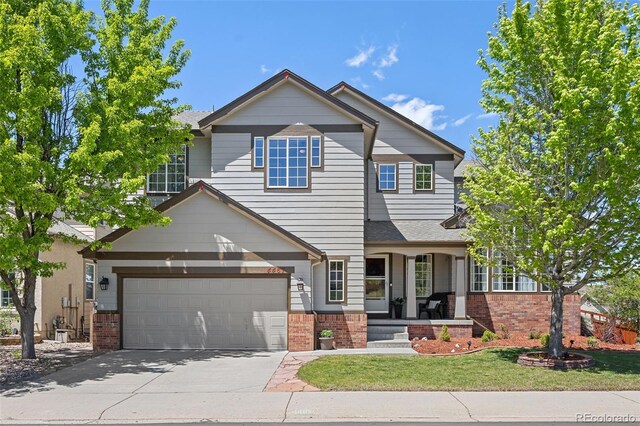 4467 Trailside Ln, Castle Rock, CO 80109 - view of front of property with brick siding, covered porch, driveway, and a front yard