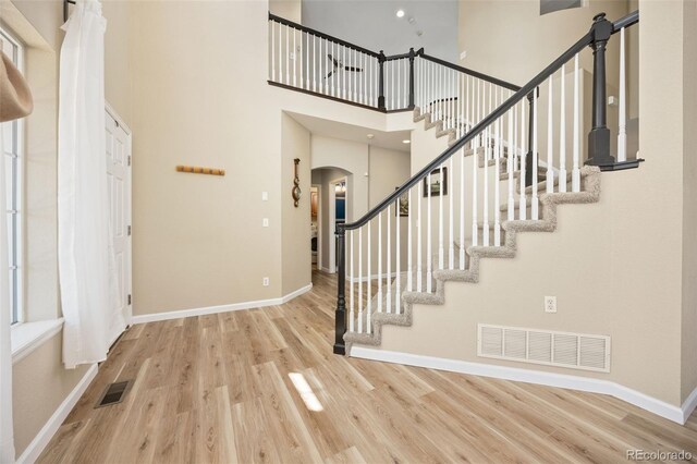 4467 Trailside Ln, Castle Rock, CO 80109 - foyer with arched walkways, wood finished floors, baseboards, stairs, and a high ceiling