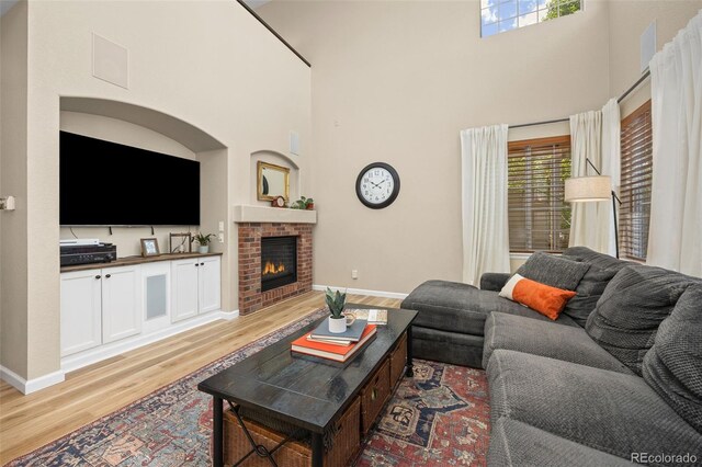 4467 Trailside Ln, Castle Rock, CO 80109 - living room featuring wood finished floors, a towering ceiling, baseboards, and a fireplace