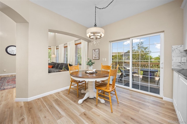 4467 Trailside Ln, Castle Rock, CO 80109 - dining space with arched walkways, light wood-type flooring, and healthy amount of natural light
