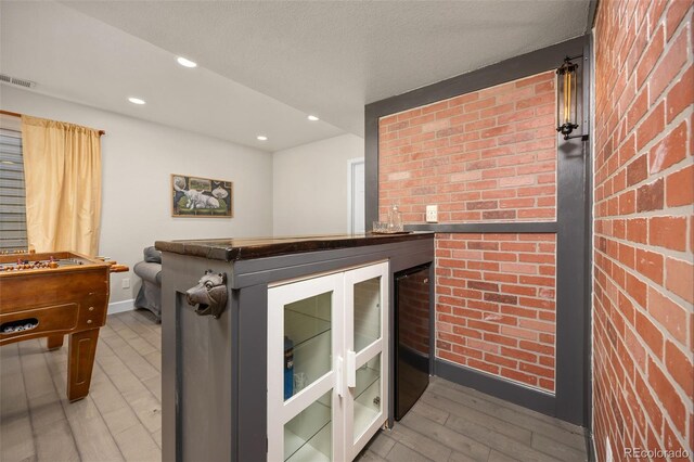 4467 Trailside Ln, Castle Rock, CO 80109 - interior space with light wood-type flooring, wine cooler, brick wall, baseboards, and recessed lighting