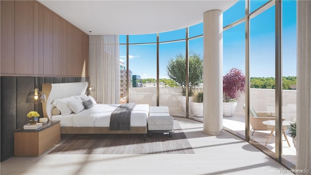 bedroom featuring access to exterior, expansive windows, and wood finished floors