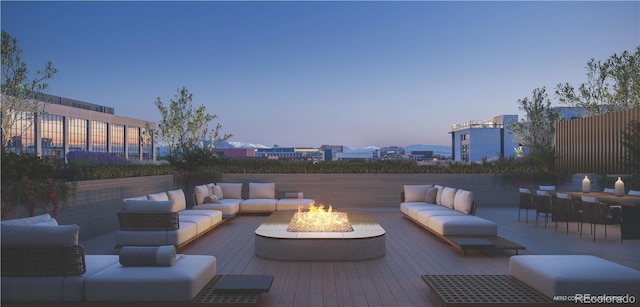 patio terrace at dusk featuring fence and an outdoor living space with a fire pit