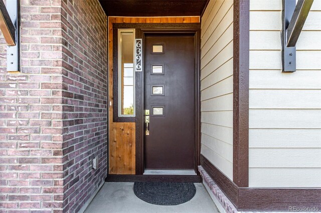 view of exterior entry with brick siding