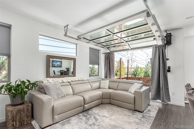 living room with wood finished floors, plenty of natural light, and baseboards