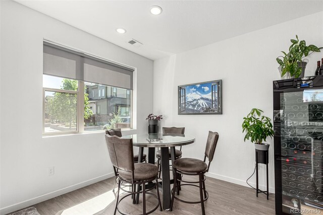 dining room featuring baseboards, wood finished floors, and recessed lighting