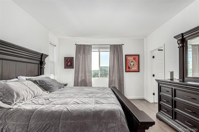 bedroom with wood finished floors and baseboards