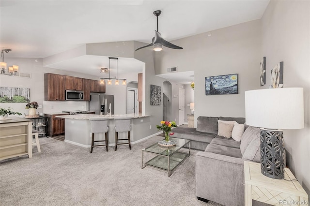 2955 Blue Sky Cir Unit 6-307, Erie, CO 80516 - living room featuring light colored carpet, a ceiling fan, arched walkways, a chandelier, and high vaulted ceiling