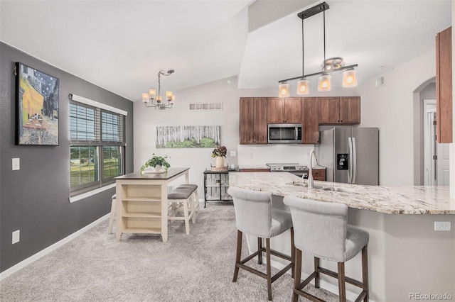 2955 Blue Sky Cir Unit 6-307, Erie, CO 80516 - kitchen featuring appliances with stainless steel finishes, vaulted ceiling, a chandelier, arched walkways, and light carpet