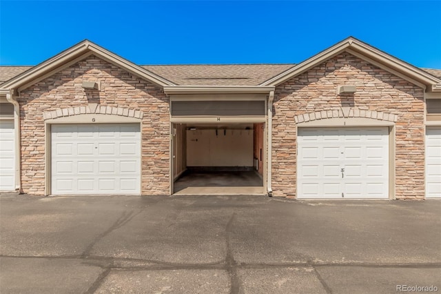 2955 Blue Sky Cir Unit 6-307, Erie, CO 80516 - single story home featuring community garages, a shingled roof, and stone siding