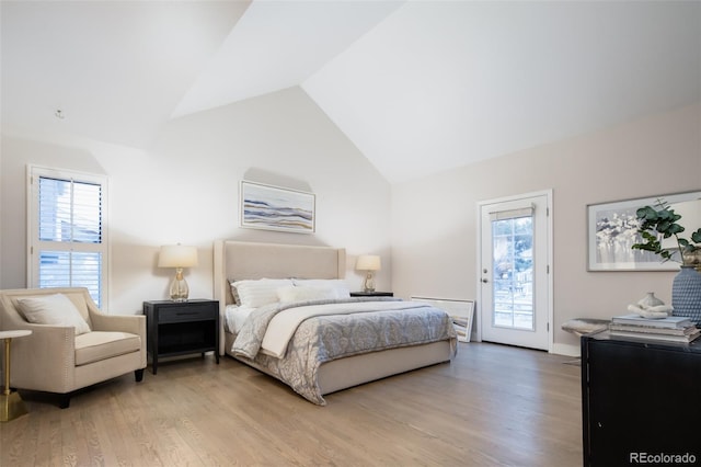 bedroom with light wood-type flooring, access to exterior, multiple windows, and high vaulted ceiling