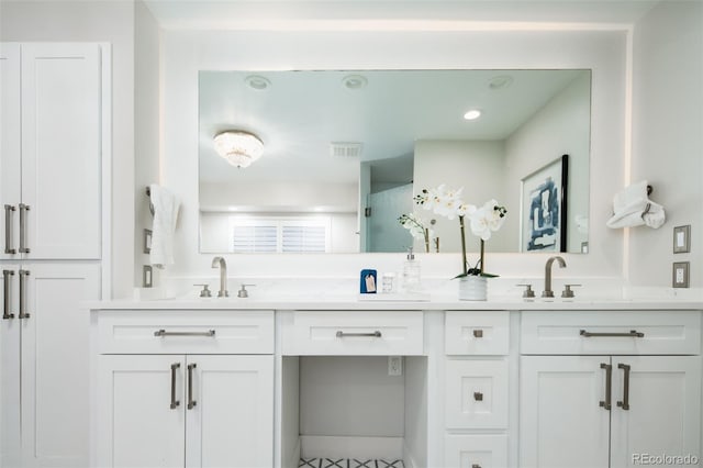 bathroom with visible vents, a sink, and double vanity