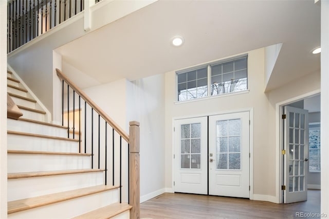 foyer featuring french doors, recessed lighting, wood finished floors, and baseboards