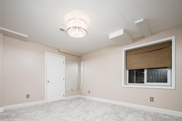 empty room with carpet, visible vents, and baseboards