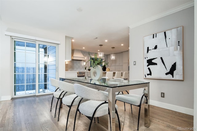 dining room featuring recessed lighting, wood finished floors, crown molding, and baseboards