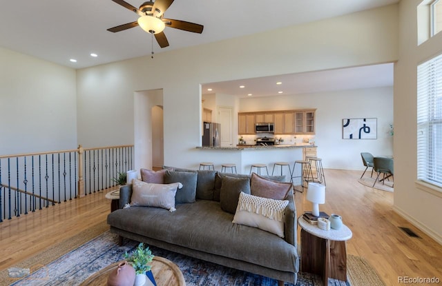 living room featuring ceiling fan and light hardwood / wood-style flooring