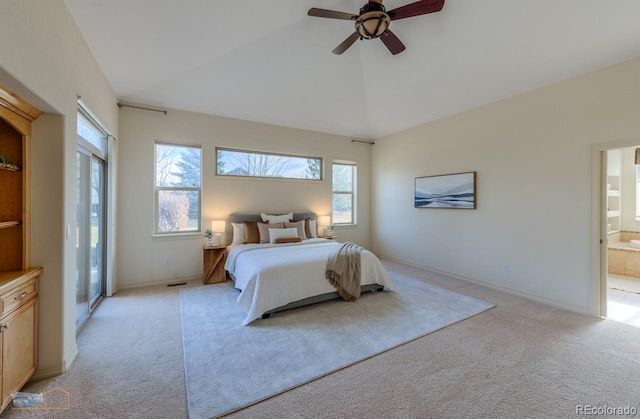 bedroom featuring multiple windows, ensuite bathroom, lofted ceiling, and light colored carpet